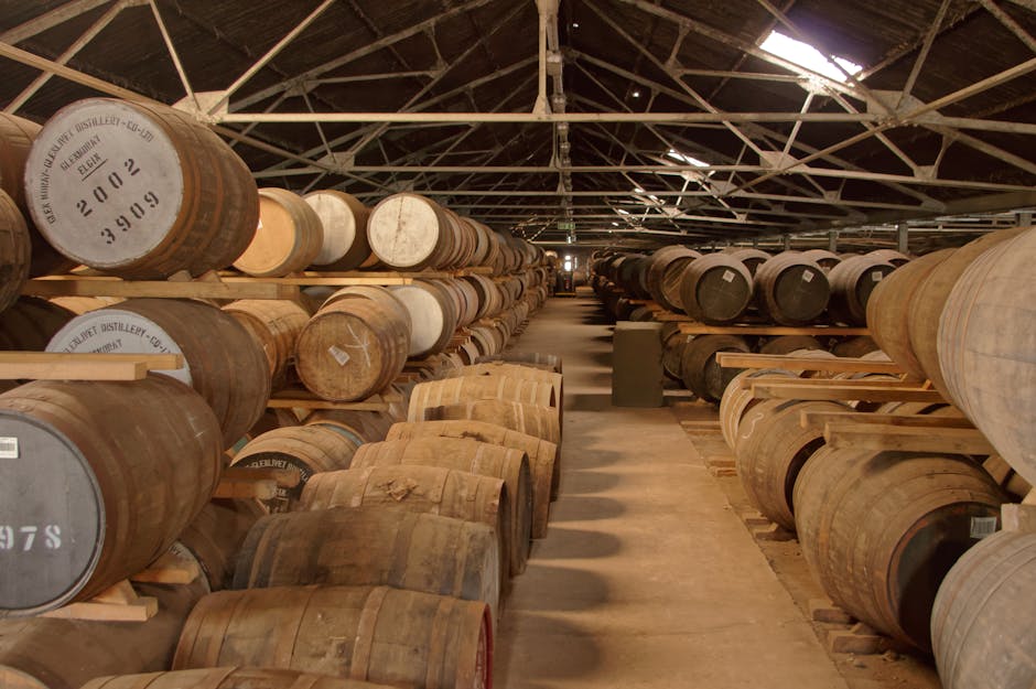 Rows of wooden barrels aging in a historic distillery warehouse, creating a rustic atmosphere.