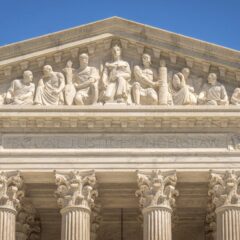 Detailed view of the Supreme Court Building's frontal frieze depicting historical figures and justices.