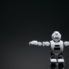 Studio shot of a humanoid robot with glowing eyes against a dark background, offering ample copyspace.