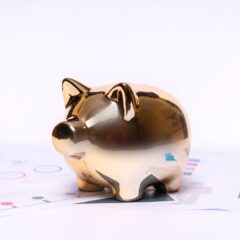 Close-up of a golden piggy bank on financial documents, symbolizing savings and investment.