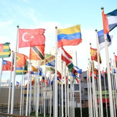 A vibrant collection of international flags in a cityscape setting, symbolizing global unity.