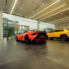 Showroom featuring luxury sports cars, Lamborghini models, with sleek design and modern architecture.