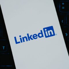 Close-up of LinkedIn logo on smartphone screen, with keyboard background.