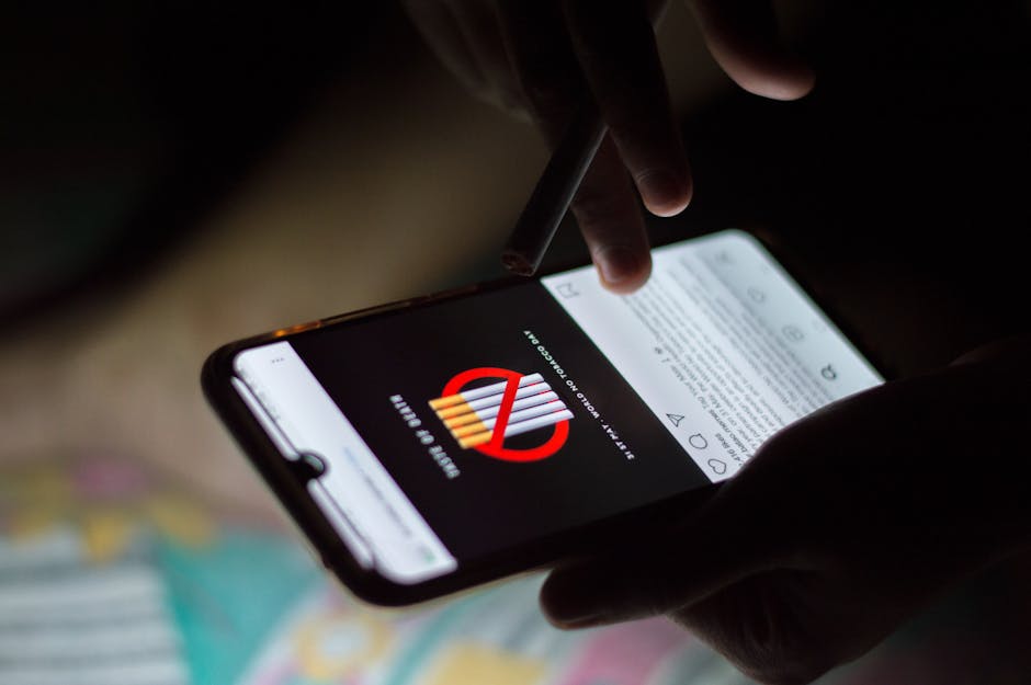 A person browsing social media on a smartphone at night, holding a cigarette.