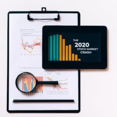 Tablet and clipboard with charts illustrating the 2020 stock market crash.