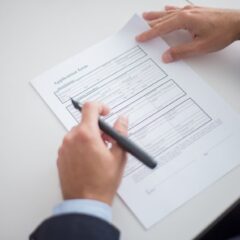 Close-up of a business professional reviewing an application form at a desk.