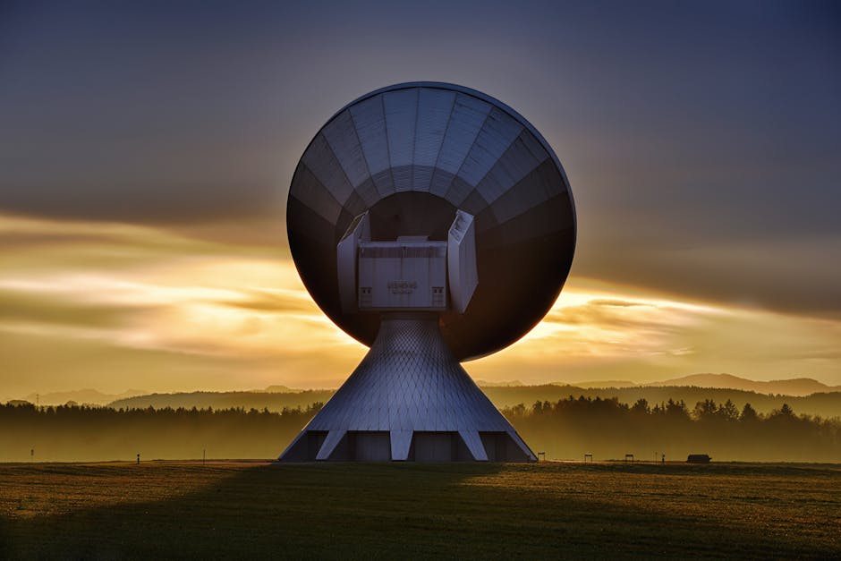 Large satellite dish silhouette against a colorful sunset, showcasing broadcasting technology.