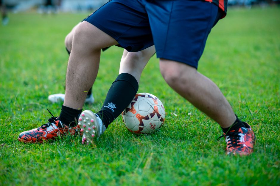 Close-up of two soccer players competing for the ball on a grassy field.