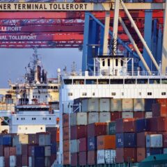 Container ships docked at Tollerort Terminal, Hamburg during sunset.