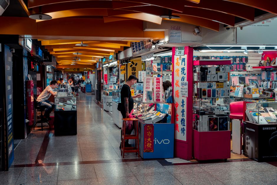 Busy indoor electronics market with modern design and engaged shoppers.