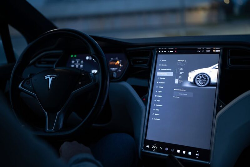 Tesla car interior showcasing advanced touchscreen display and steering controls.