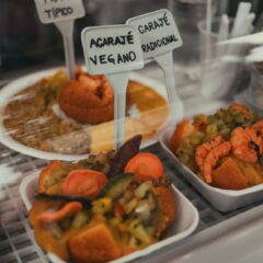 Close-up of acarajé and vegetarian options in a Brazilian display. Perfect for food lovers.