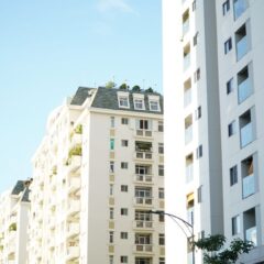 Bright day view of white urban residential apartment buildings.