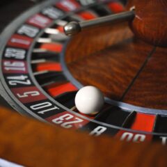 Detailed close-up image of roulette wheel highlighting numbers and spinning ball in a casino setting.