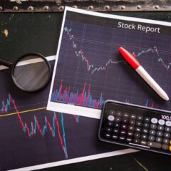 Stock report with charts, calculator, and magnifying glass for financial analysis.