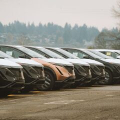 Rows of sleek electric cars parked outdoors, showcasing automotive design and innovation.