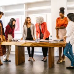 A diverse group of women collaborating on a project in a modern office setting.