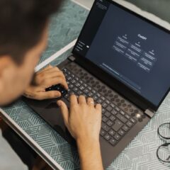 A man working on a laptop with AI software open on the screen, wearing eyeglasses.