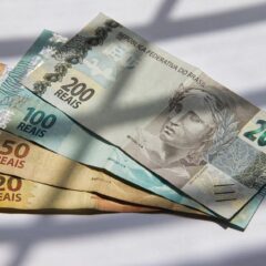 Various Brazilian real banknotes in sunlight, showcasing currency variety.