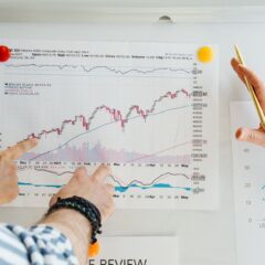 Two professionals analyze stock market graphs with a focus on finance and data trends.