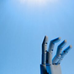 Robotic hand with articulated fingers reaching towards the sky on a blue background.