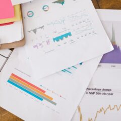 Close-up of business analytics charts and graphs on papers and clipboard.