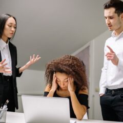 Diverse coworkers in an office dealing with a stressful work situation around a laptop.