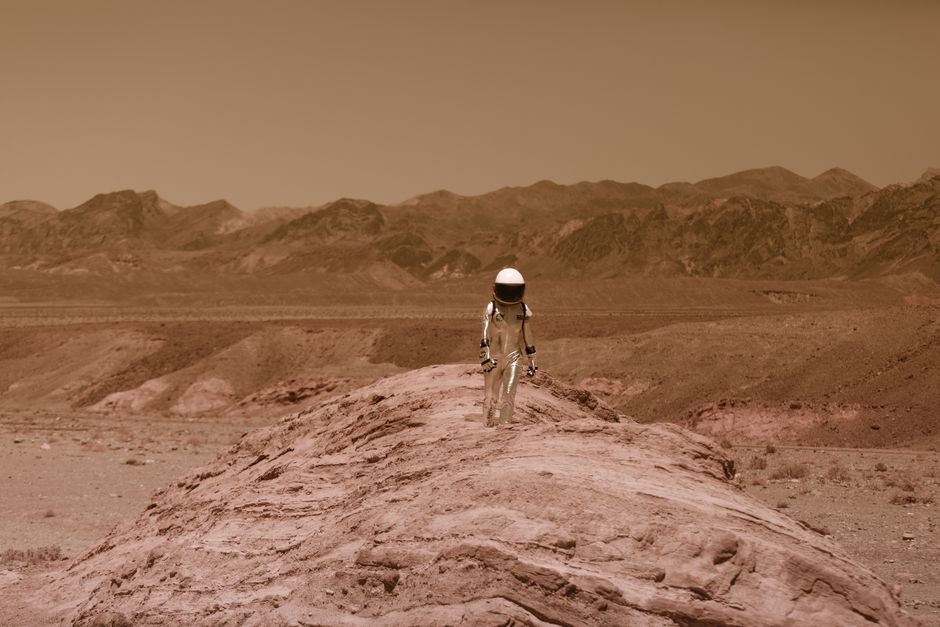 Astronaut walking on a barren, Mars-like desert landscape, depicting adventure and exploration.